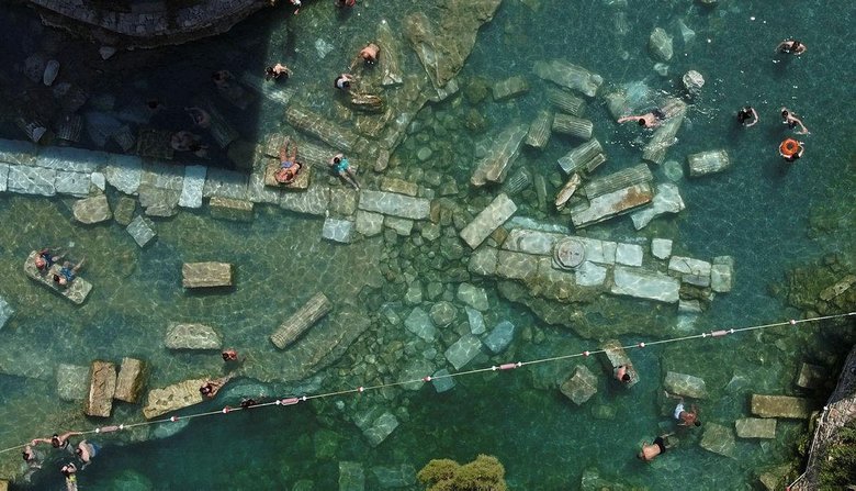 Pamukkale’de 36 derecelik sıcaklığa sahip antik havuz sıcak havada da ilgi görüyor