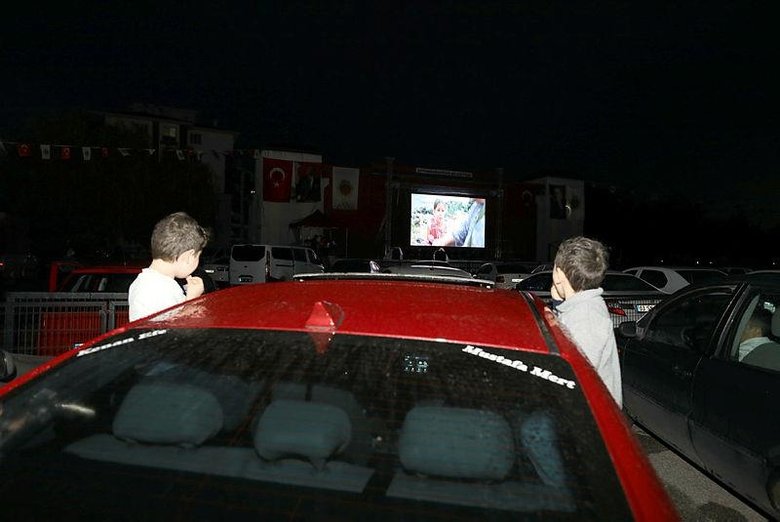 Arabada sinema keyfi! Yağmur altında film izlediler