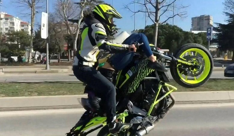 Sevgilisini sırtüstü motosiklete yatırıp tek teker üstünde gitti