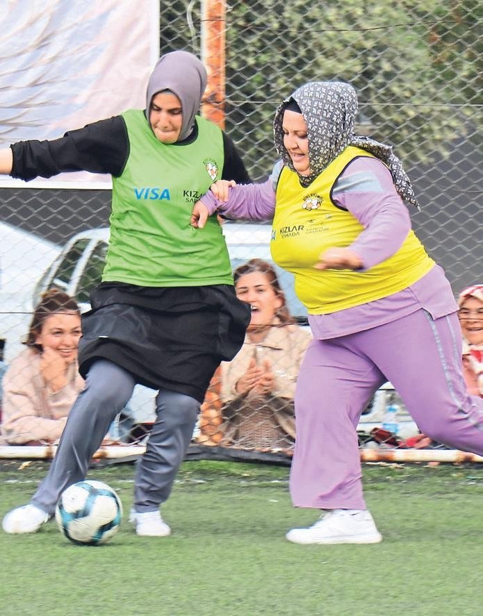 Kızlar kenarda anneleri sahada