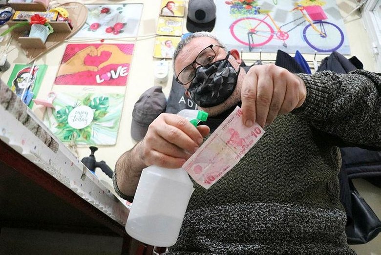 Paraları dezenfektanla yıkayıp, sobada kurutuyor